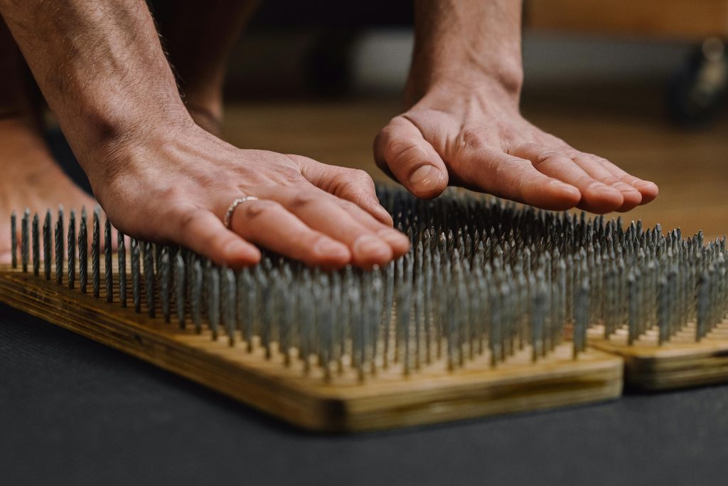 Hands hovering over acupuncture board